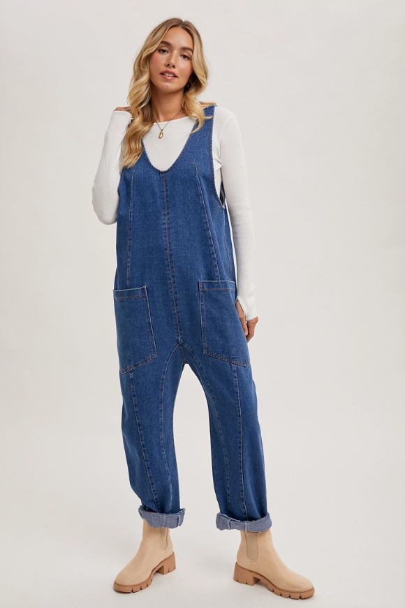 Model wearing relaxed-fit denim jumpsuit with high-rise harem style legs