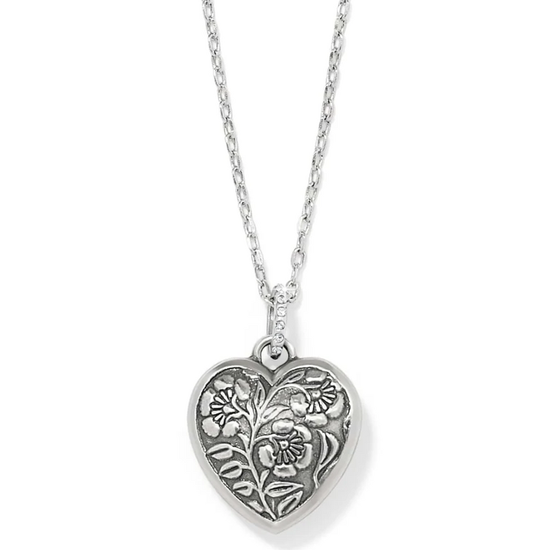 Close-up of silver heart pendant with sparkling sapphire crystals