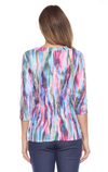 Carine Carlie V-neck top with three-quarter sleeves, scrunched drawstring detail on the left hip, and lightweight crinkle fabric with laser burnout, perfect for travel. In the pattern Aurora Flame.