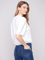 Side view of knit sweater showing cropped hem