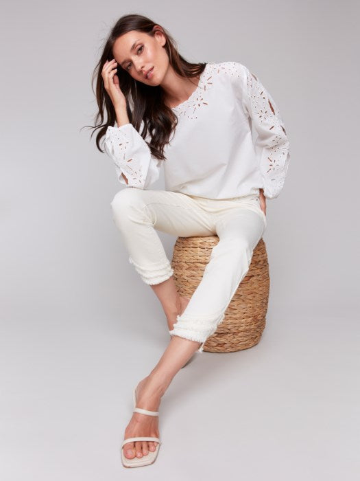 Model wearing feminine white eyelet blouse with balloon sleeves in white