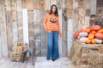 Cozy fall sweater featuring jack-o-lantern design in relaxed fit