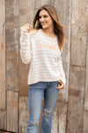 Model wearing the Pumpkin Striped Crew in a cozy fall setting