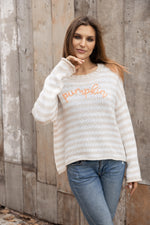 Model wearing the Pumpkin Striped Crew in a cozy fall setting