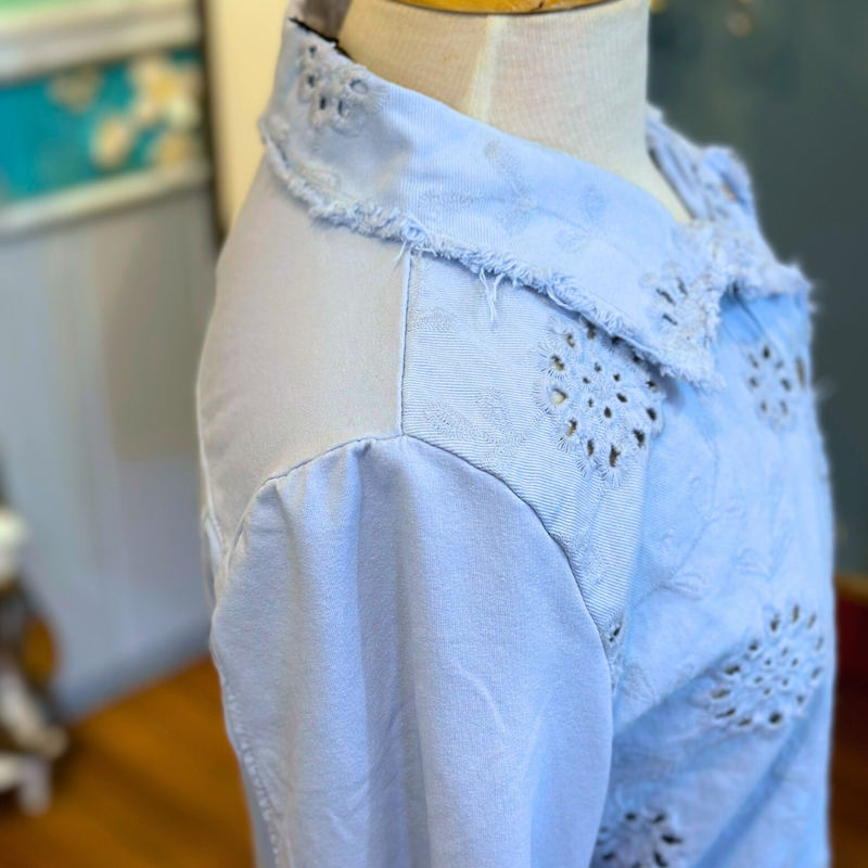 Femme Fatale Embroidered Eyelet Jacket – Women's cropped spring jacket with button front, eyelet embroidery, frayed edges, and soft stretch jersey sleeves and back. Stylish and versatile layering piece. In the color Ice.