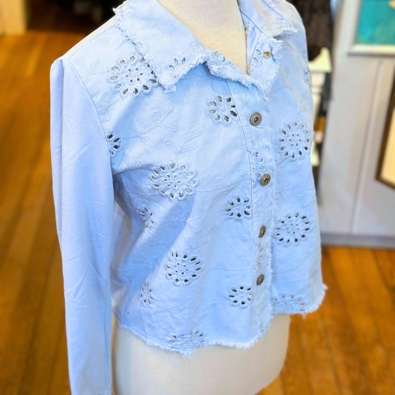 Femme Fatale Embroidered Eyelet Jacket – Women's cropped spring jacket with button front, eyelet embroidery, frayed edges, and soft stretch jersey sleeves and back. Stylish and versatile layering piece. In the color Ice.