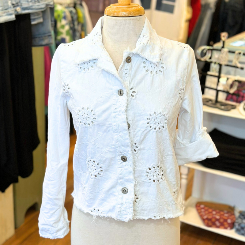 Femme Fatale Embroidered Eyelet Jacket – Women's cropped spring jacket with button front, eyelet embroidery, frayed edges, and soft stretch jersey sleeves and back. Stylish and versatile layering piece. In the color White.