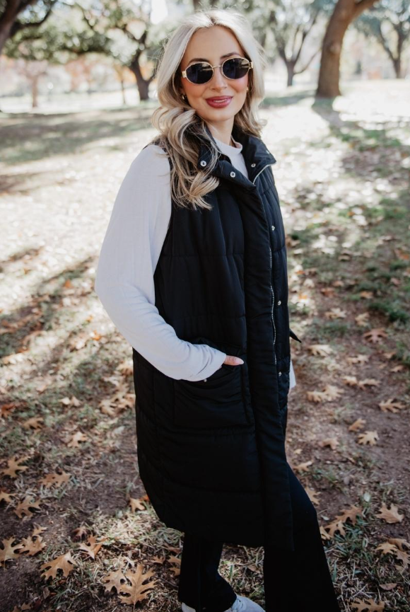 Black long quilted puffer vest with button and zipper closure