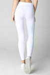 Person wearing white leggings on a plain background
