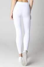 Person wearing white leggings on a plain background