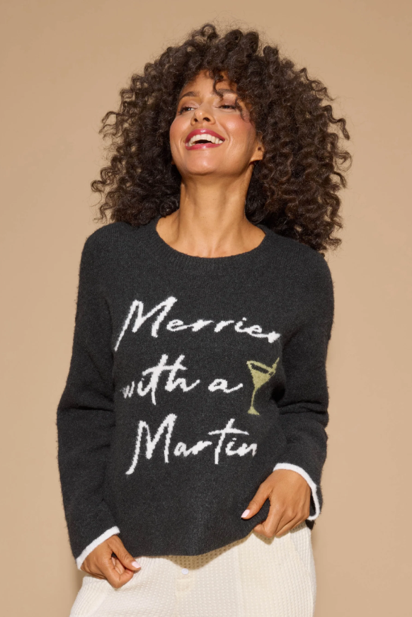 Women’s black snuggle knit sweater with “Merrier with a Martini” graphic.