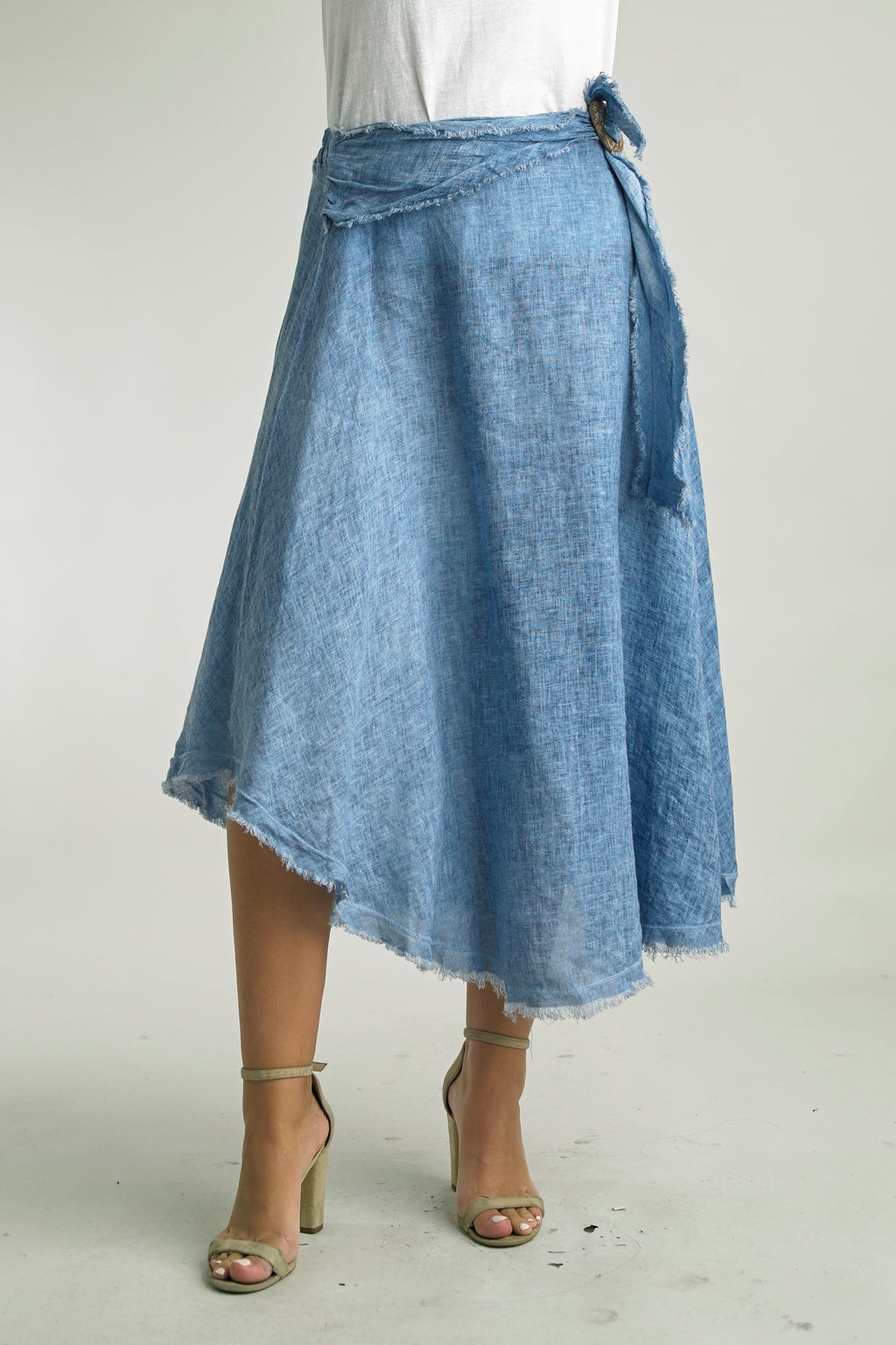 Asymmetrical midi skirt with frayed hem and wrap waist in the color Denim