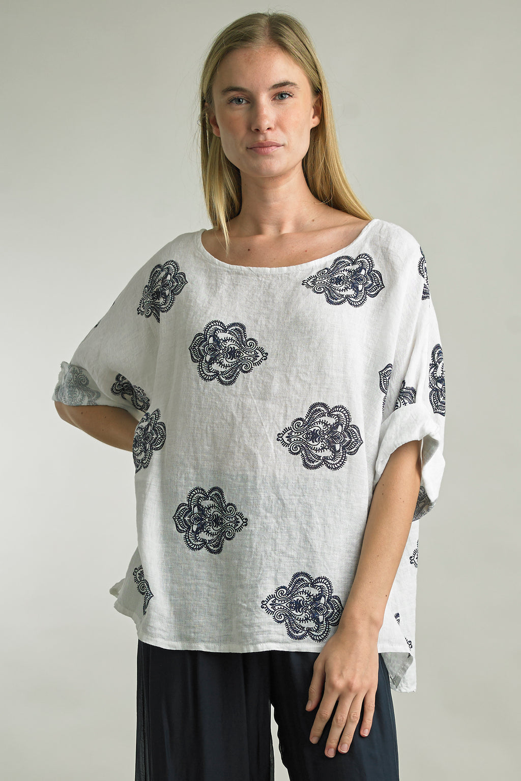 Woman wearing oversized printed linen top with rolled sleeves in the color White