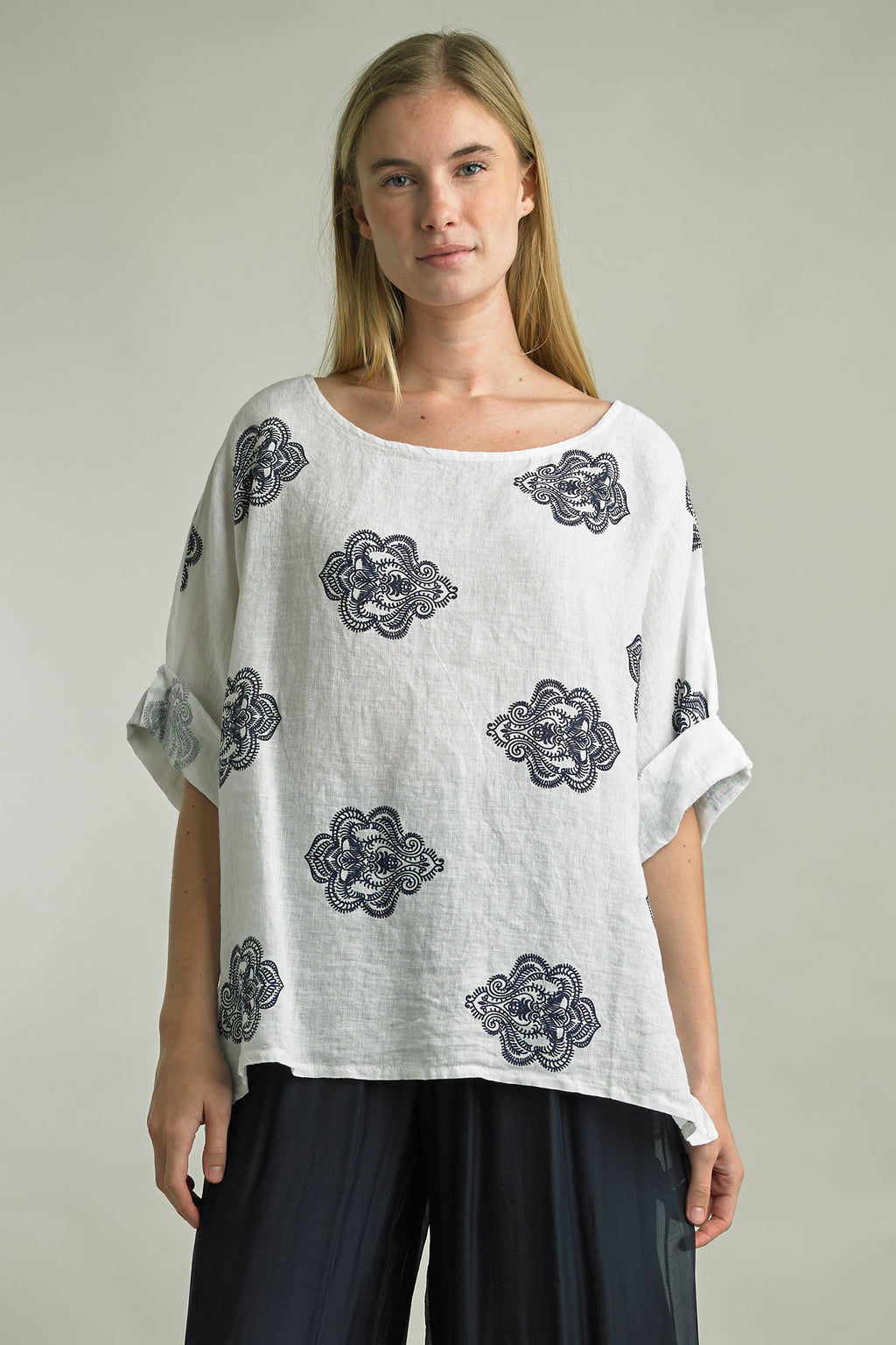 Woman wearing oversized printed linen top with rolled sleeves in the color White