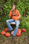 Cozy fall sweater featuring jack-o-lantern design in relaxed fit
