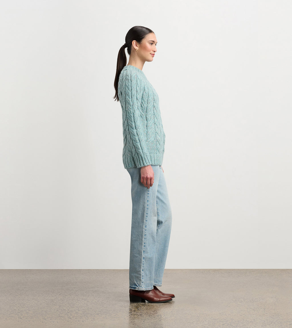Soft turquoise cable knit sweater with mock neckline and relaxed fit