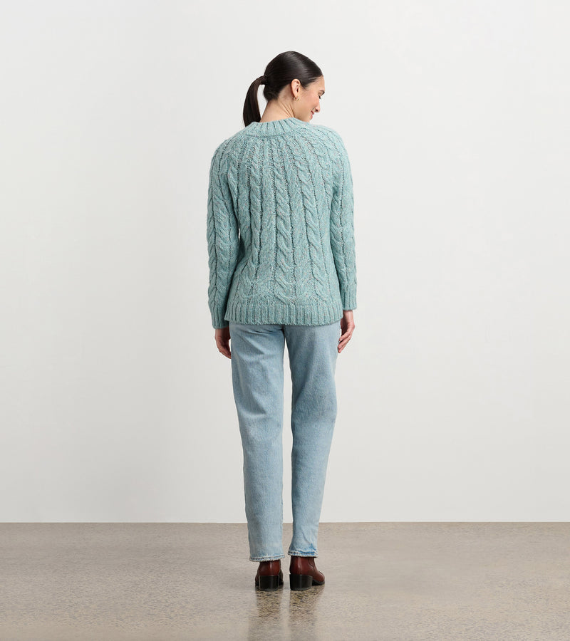 Model wearing Dylan Cable Knit Sweater in soft turquoise with jeans